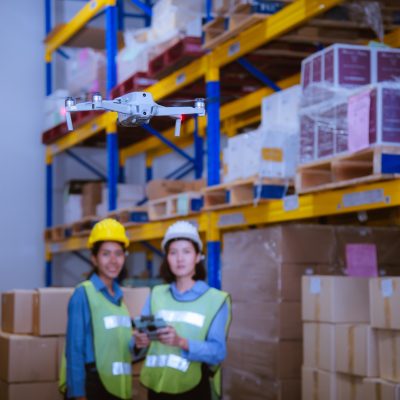 Industry engineer and worker under operation control drone flying work in factory and see detail ind